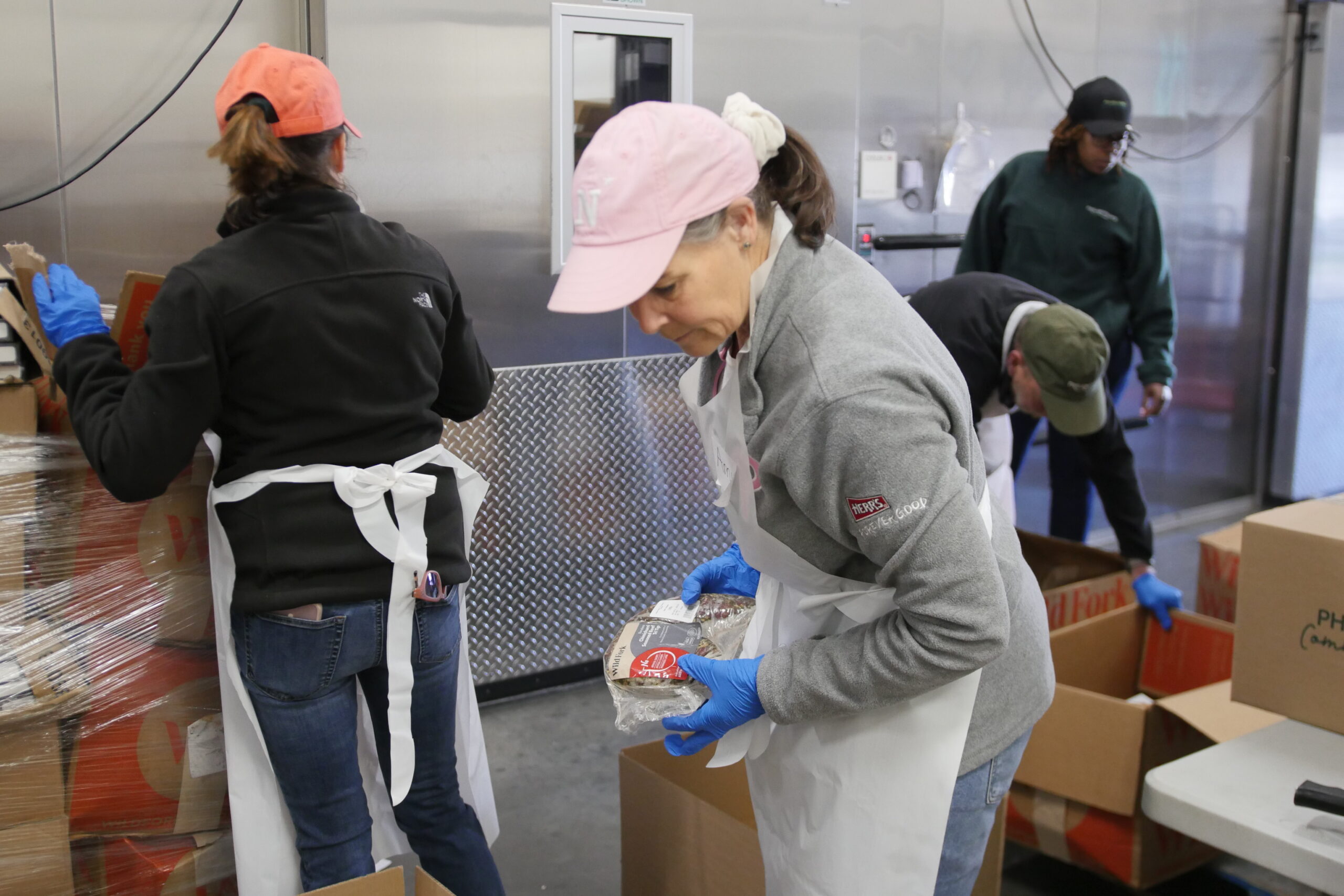 Four Philabundance Community Kitchen Volunteers examining packed food boxes